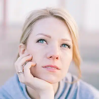 close-up portrait of fair-skinned, blonde woman with a pondering look on her face